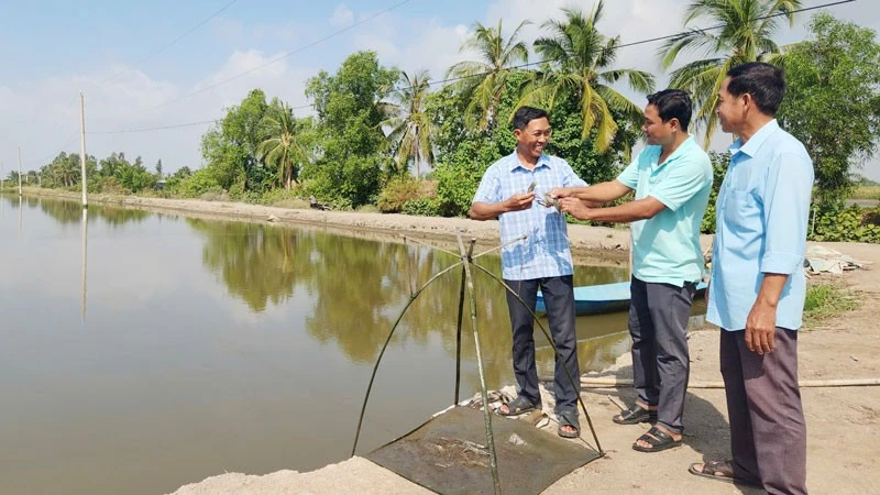Đảng viên Chương Văn Sáng (giữa), Trưởng ấp Đồng Tranh, xã Vĩnh Bình, tỉnh An Giang sát cánh cùng nhân dân.