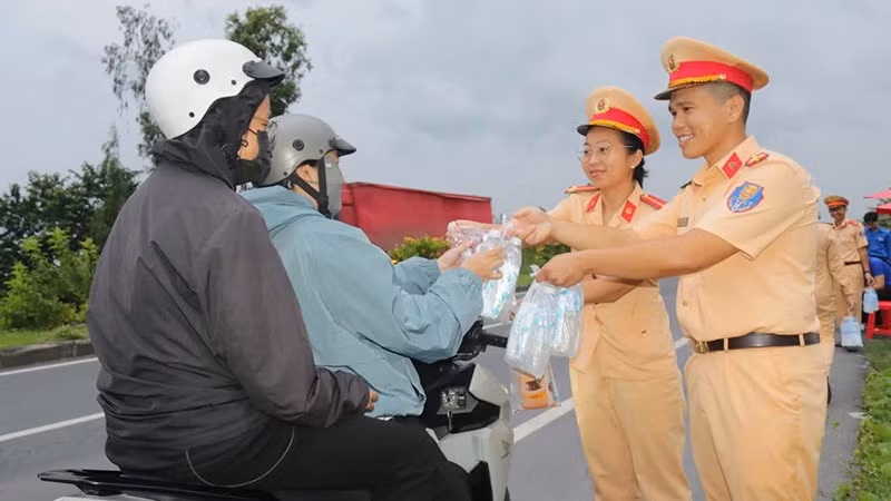 Nữ cảnh sát giao thông cùng đồng đội cấp phát nước miễn phí cho người dân về quê trong các dịp lễ, Tết.