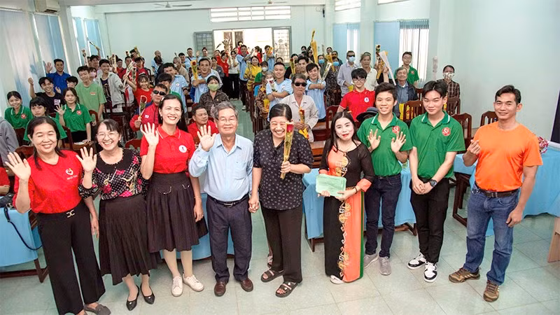 Cô Nguyễn Thị Minh Tâm và ông Huỳnh Văn Bé (đứng thứ 3, thứ 4 từ trái qua) tổ chức hoạt động cho người khuyết tật.
