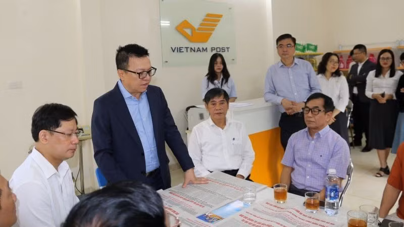 Tổng Biên tập Báo Nhân Dân Lê Quốc Minh trao đổi với người dân địa phương về ý nghĩa của phụ trương công bố dự thảo các văn kiện trình Đại hội XIV do Báo Nhân Dân phát hành.