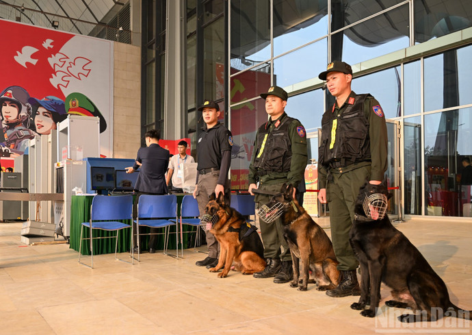 Cán bộ, chiến sĩ cùng chó nghiệp vụ làm nhiệm vụ tại Trung tâm Hội nghị quốc gia. (Ảnh: DUY LINH)