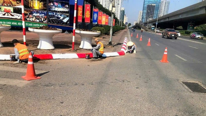 Công nhân sơn sửa, thay thế cột biển báo, vệ sinh mặt biển phản quang; rửa trụ đèn tín hiệu, hàng rào dải phân cách trên các tuyến phố.