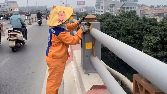Công nhân vệ sinh lan can, miếng dán phản quang trên Cầu Thanh Trì.
