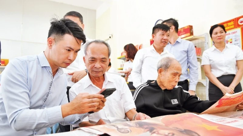 Жители знакомятся с приложением, содержащим проекты документов XIV съезда Партии, в культурно-почтовом пункте общины Зачать провинции Хынгйен. (Фото: Тхэ Дай)