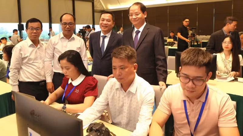Các đại biểu tham quan quy trình tác nghiệp của phóng viên tại Trung tâm báo chí.