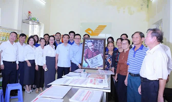 Đồng chí Lê Quốc Minh trao tặng bức tranh Bác Hồ đọc Báo Nhân Dân cho cán bộ, Đảng viên, nhân dân xã Tân Hưng tại điểm bưu điện văn hóa xã Tân Hưng (Hưng Yên).