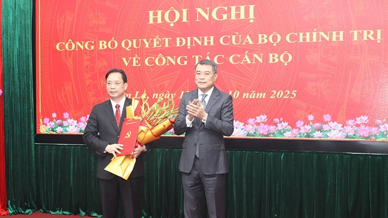 Đồng chí Lê Minh Hưng, Ủy viên Bộ Chính trị, Bí thư Trung ương Đảng, Trưởng ban Tổ chức Trung ương trao quyết định của Bộ Chính trị và tặng hoa chúc mừng đồng chí Hoàng Văn Nghiệm.