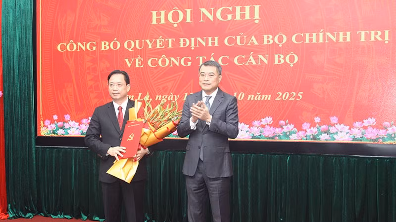 Đồng chí Lê Minh Hưng, Ủy viên Bộ Chính trị, Bí thư Trung ương Đảng, Trưởng ban Tổ chức Trung ương trao quyết định của Bộ Chính trị và tặng hoa chúc mừng đồng chí Hoàng Văn Nghiệm.