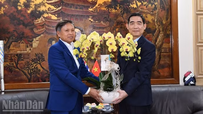 Đại sứ Lào tại Thái Lan Sisavath Inphachanh trao lẵng hoa chúc mừng Đại hội XIV của Đảng thành công tốt đẹp. (Ảnh: XUÂN SƠN)