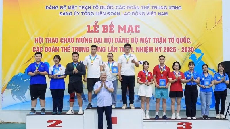 Đồng chí Đỗ Văn Chiến, Ủy viên Bộ Chính trị, Chủ tịch Ủy ban Trung ương Mặt trận Tổ quốc Việt Nam trao giải cho các đội đoạt giải Nhất, Nhì, Ba môn kéo co. (Ảnh: HỮU CHÁNH)