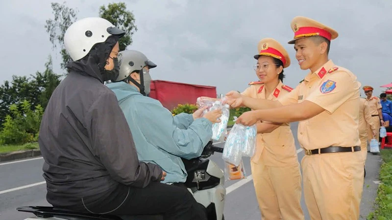 Nữ cảnh sát giao thông cùng đồng đội cấp phát nước miễn phí cho người dân về quê trong các dịp lễ, Tết.