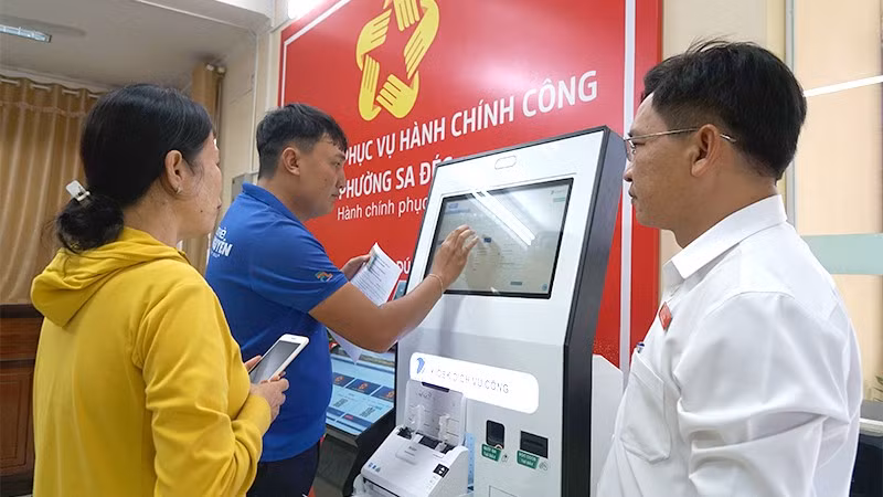 Đoàn viên-thanh niên và cán bộ Trung tâm Phục vụ hành chính công phường Sa Đéc hỗ trợ người dân nộp hồ sơ tại Kiosk thông minh.