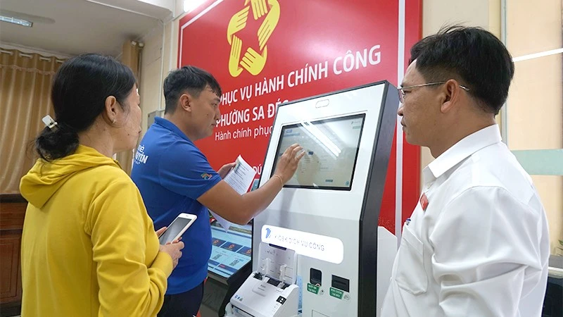 Đoàn viên-thanh niên và cán bộ Trung tâm Phục vụ hành chính công phường Sa Đéc hỗ trợ người dân nộp hồ sơ tại Kiosk thông minh.