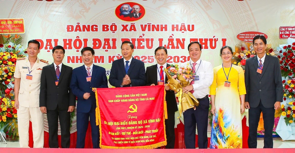 Đồng chí Huỳnh Quốc Việt, Ủy viên dự khuyết Trung ương Đảng, Phó Bí thư Thường trực Tỉnh ủy Cà Mau (áo trắng) trao bức trướng của Ban Chấp hành Đảng bộ tỉnh tặng Đảng bộ xã Vĩnh Hậu, nhân dịp Đại hội Đảng bộ xã lần thứ I, nhiệm kỳ 2025-2030. (Ảnh: TRỌNG DUY)