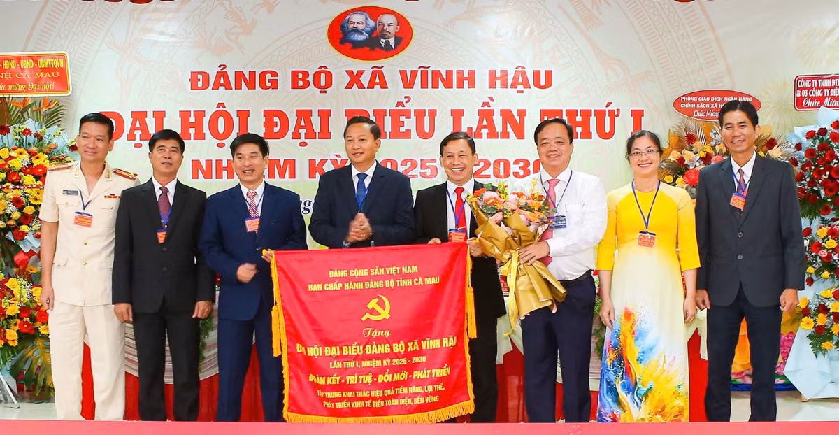 Đồng chí Huỳnh Quốc Việt, Ủy viên dự khuyết Trung ương Đảng, Phó Bí thư Thường trực Tỉnh ủy Cà Mau (áo trắng) trao bức trướng của Ban Chấp hành Đảng bộ tỉnh tặng Đảng bộ xã Vĩnh Hậu, nhân dịp Đại hội Đảng bộ xã lần thứ I, nhiệm kỳ 2025-2030. (Ảnh: TRỌNG DUY)