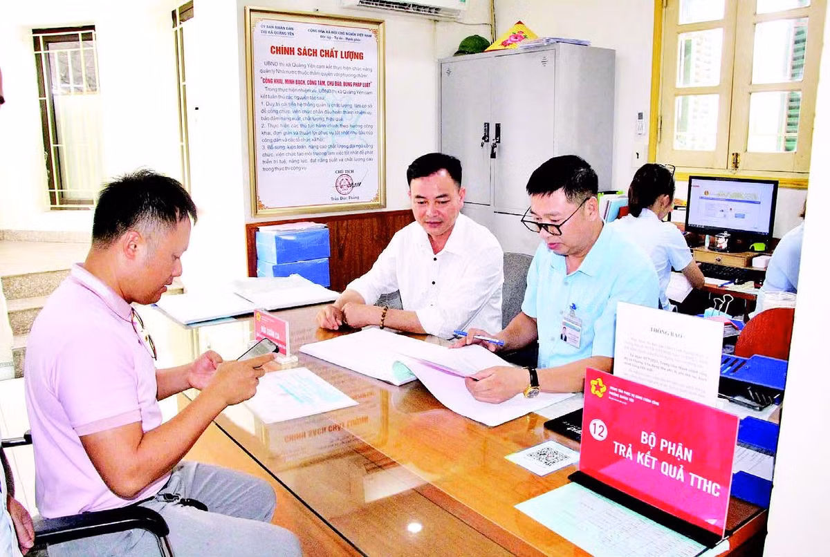 Cán bộ Trung tâm Phục vụ hành chính công phường Quảng Yên (tỉnh Quảng Ninh) hỗ trợ người dân làm thủ tục hành chính. (Ảnh QUANG THỌ)